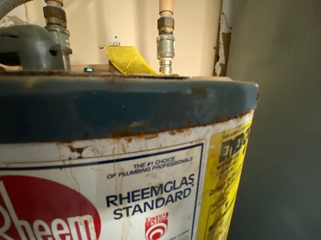 Inspector checking the age and condition of a water heater during a Florida home inspection